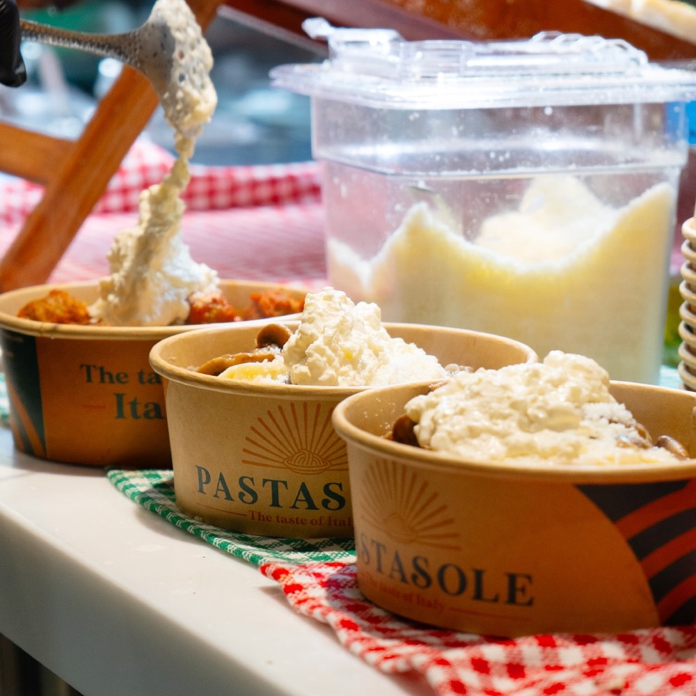 Fresh burrata spooned onto Pastasole pasta bowls at the counter