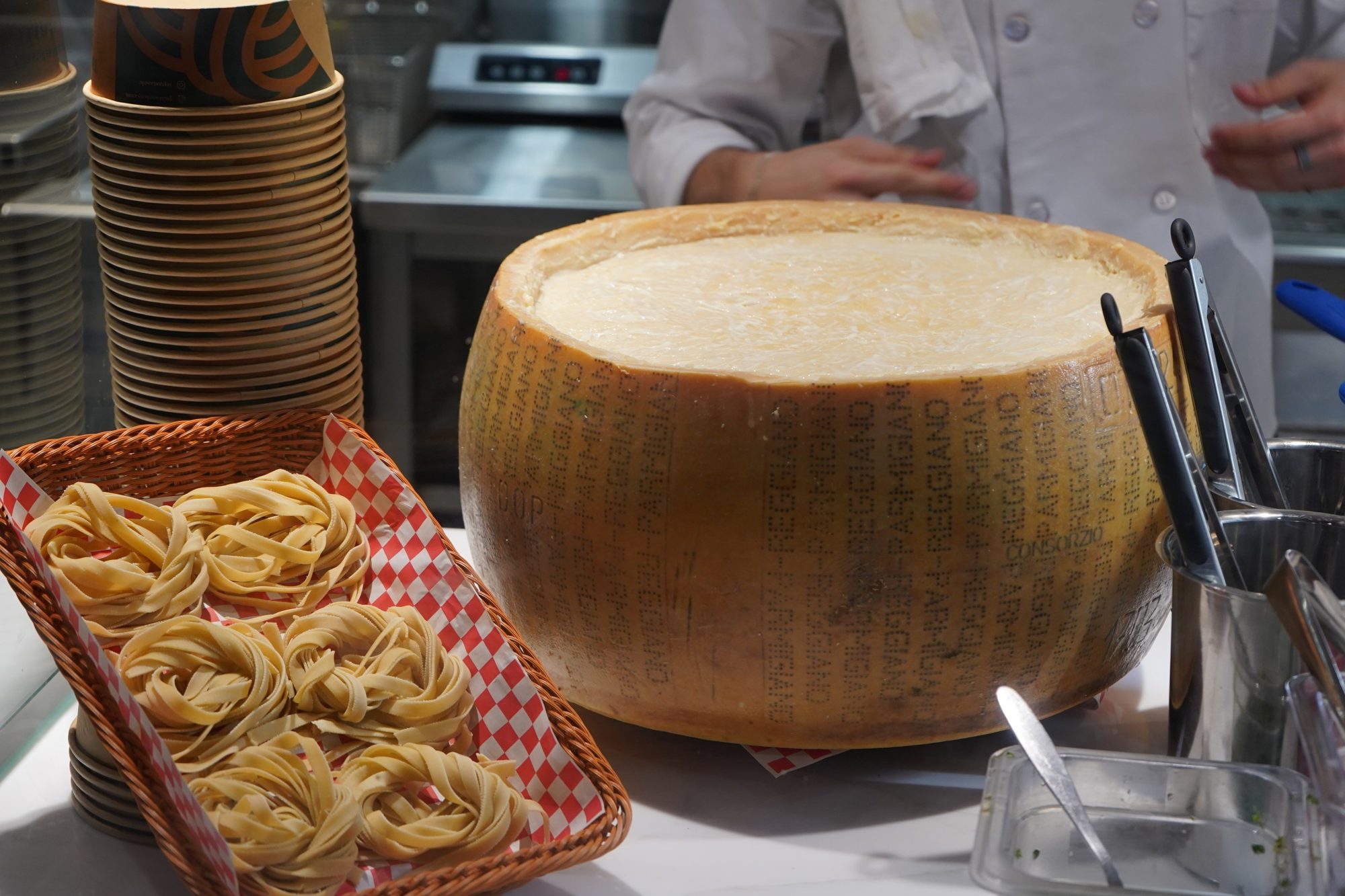 Nests of fresh fettuccine next to a Parmigiano Reggiano wheel at the Pastasole counter